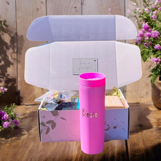 a pink cup sitting next to a cardboard box