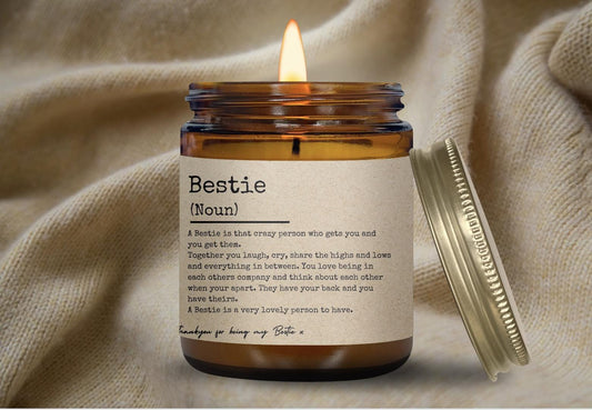 a candle that is sitting on a blanket that says bestie